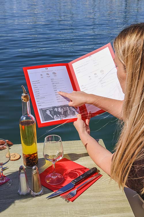 Cliente consultant la carte du restaurant Gaetano au bord de l'eau au port de Toulon